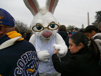 A White House official escorts a person in an Easter Bunny costume at the 2024 White House Easter Egg Roll on the South Lawn of the White Ho...