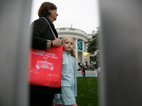 Seen beyond a picket fence, people attend the 2024 White House Easter Egg Roll on the South Lawn of the White House in Washington, D.C. on A...