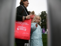 Seen beyond a picket fence, people attend the 2024 White House Easter Egg Roll on the South Lawn of the White House in Washington, D.C. on A...