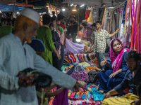 Customers are gathering at a market to purchase dresses from a weekly market in a low-income area ahead of Eid ul Fitr in Dhaka, Bangladesh,...