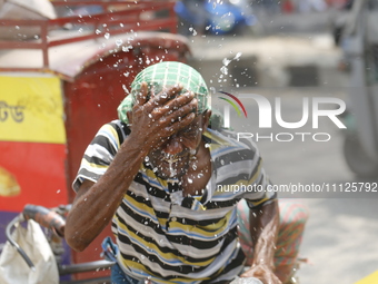 A rickshaw puller is splashing water on his face to get relief during a heatwave in Dhaka, Bangladesh, on April 6, 2024. According to the Me...