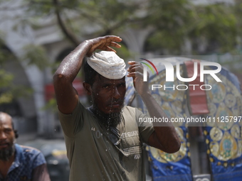 A rickshaw puller is putting a wet cap on his head to get relief from a heatwave in Dhaka, Bangladesh, on April 6, 2024. According to the Me...