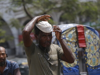 A rickshaw puller is putting a wet cap on his head to get relief from a heatwave in Dhaka, Bangladesh, on April 6, 2024. According to the Me...