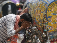 A rickshaw puller is splashing water on his face to get relief during a heatwave in Dhaka, Bangladesh, on April 6, 2024. According to the Me...