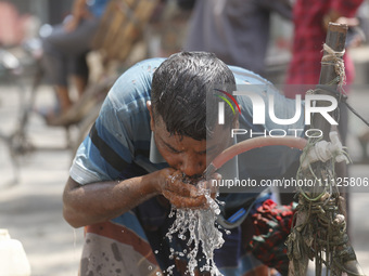 A rickshaw driver is drinking water from a roadside tap to find relief during a heatwave in Dhaka, Bangladesh, on April 6, 2024. The Met Off...