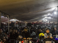 Motorbike riders are waiting in line to board a ship that will take them to their hometown ahead of Eid al-Fitr, known as 'Mudik', at Ciwand...