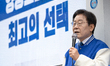 Lee Jae-myung, the leader of the Democratic Party, is standing at the center with his hand...