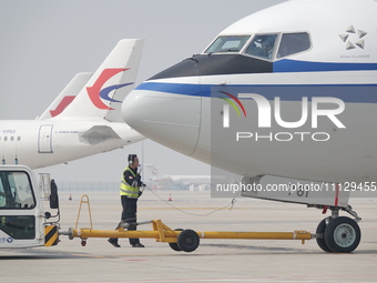 Ground crew members are preparing for the launch of an aircraft at Yantai Penglai International Airport in Yantai, China, on April 7, 2024....