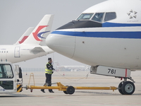 Ground crew members are preparing for the launch of an aircraft at Yantai Penglai International Airport in Yantai, China, on April 7, 2024....