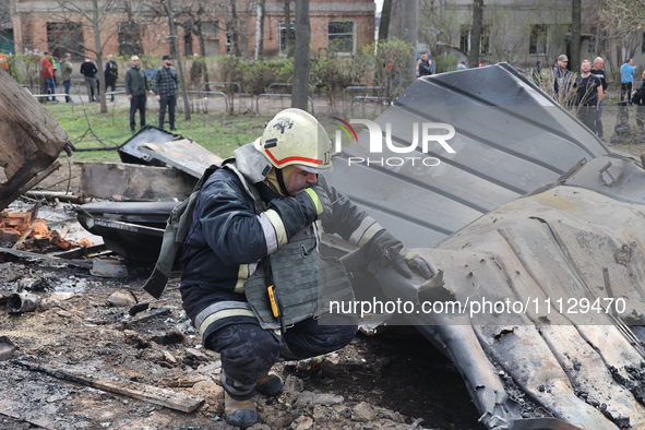 A rescuer is examining the wreckage after a Russian precision-guided munition hit civil infrastructure in Kharkiv, northeastern Ukraine, on...
