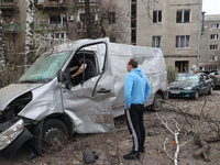 Two men are examining a damaged van after a Russian precision-guided munition hit civil infrastructure in Kharkiv, northeastern Ukraine, on...
