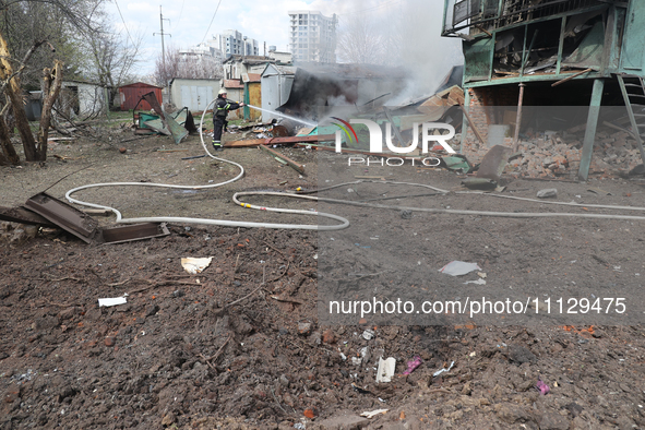 A firefighter is suppressing a fire with water after a Russian precision-guided munition hit civil infrastructure in Kharkiv, northeastern U...