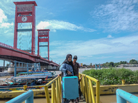 People are waiting for the ship to depart at Pier 16 Ilir in Palembang, Indonesia, on April 8, 2024. Millions of people are traveling back f...