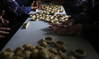 Palestinian women are volunteering in a charity initiative to prepare traditional cookies...
