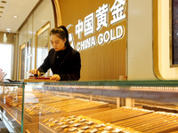 A staff member is arranging gold ornaments for sale at a gold shop in the Lianyun district, in Lianyungang, China, on April 9, 2024. (