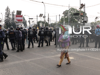 A Nepali woman is carrying her child across a road section amid a high security presence in Kathmandu, Nepal, on April 9, 2024, after right-... by Sanjit Pariyar/NurPhoto