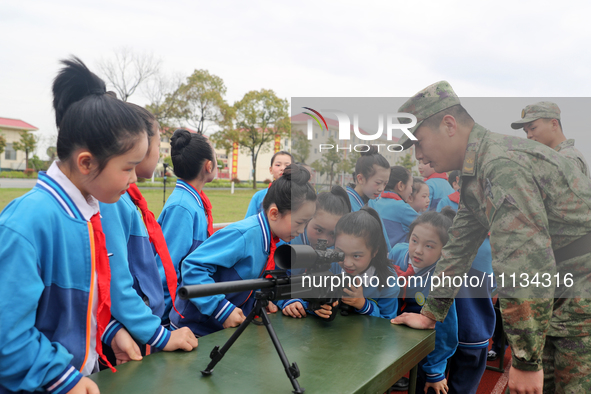 Students are experiencing individual weapons and equipment up close under the guidance of officers and soldiers in Yingtan, China, on April...