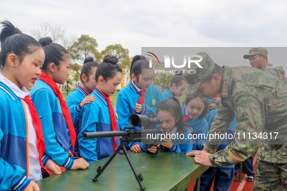 Students are experiencing individual weapons and equipment up close under the guidance of officers and soldiers in Yingtan, China, on April...