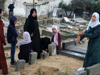 Palestinian women are gathering at a cemetery on the grave of a relative early on the first day of Eid al-Fitr, the Muslim holiday that begi...