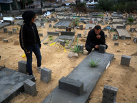 A Palestinian man is gathering at a cemetery on the grave of a relative on the first day of Eid al-Fitr, the Muslim holiday that begins at t...