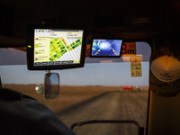 Digital monitors are being seen inside the cabin of the combine harvester. (