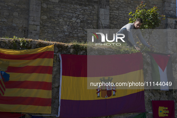 A young man is placing a Palestinian flag on the wall of the Valdenoceda cemetery in Burgos, Spain, during a tribute to those retaliated aga...