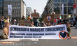 A dozen climate activists from the Last Generation group are blocking the street of Koenig...