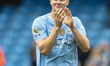Erling Haaland, wearing the number 9 jersey for Manchester City, is saluting the fans at t...