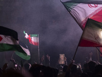 Iranians are waving Iranian flags and a Palestinian flag while one of them is holding a portrait of Qassem Soleimani, the former commander o...