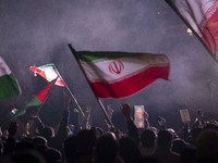Iranians are waving Iranian flags and a Palestinian flag while one of them is holding a portrait of Qassem Soleimani, the former commander o...