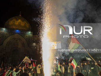 Iranians are waving an Iranian flag and a Palestinian flag as they celebrate Iran's IRGC UAV and missile attack against Israel in downtown T...