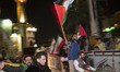 An Iranian man is holding Palestinian flags while participating in a celebration of Iran's...