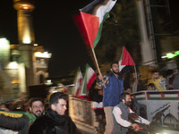 An Iranian man is holding Palestinian flags while participating in a celebration of Iran's IRGC UAV and missile attack against Israel, in do...