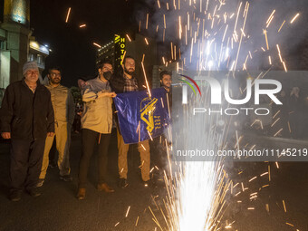 Iranians are celebrating Iran's IRGC UAV and missile attack against Israel, with one person holding a flag of the Islamic Revolutionary Guar...