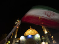 An Iranian man is waving an Iranian flag in front of a mosque during the celebration of Iran's IRGC UAV and missile attack against Israel, i...