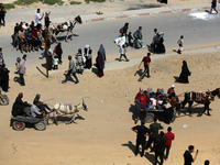 Displaced Palestinians are taking the coastal Rashid road to return to Gaza City as they pass through Nuseirat in the central Gaza Strip on...