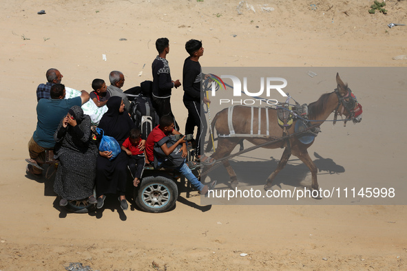 Displaced Palestinians are taking the coastal Rashid road to return to Gaza City as they pass through Nuseirat in the central Gaza Strip ami...