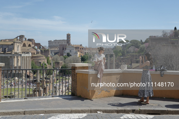 A tourist is taking a photo with the ruins of ancient Rome in the background in Rome, Italy, on April 8, 2024. Featuring 25,000 archaeologic...
