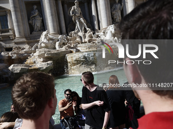 Tourists are shooting photos and throwing coins into the Trevi Fountain to ensure their return in Rome, Italy, on April 14, 2024. (