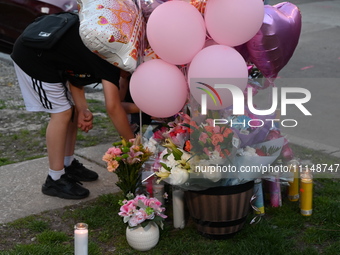 People are placing flowers, balloons, and candles at a memorial to remember the life of 9-year-old Ariana Molina, who was killed in a mass s...