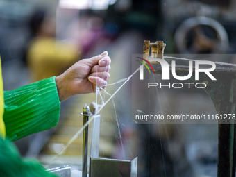 A worker is drawing silk at a mulberry silk processing workshop in Xinghua, China, on April 20, 2024. (