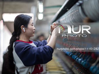 A worker is drawing silk at a mulberry silk processing workshop in Xinghua, China, on April 20, 2024. (