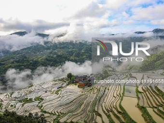 An aerial photo is showing clouds shrouding the terraced fields of Kampung deep in the mountains in Congjiang County, Qiandongnan Miao and D...