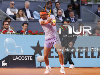 Rafael Nadal is returning a shot against Darwin Blanch during their match on Day 4 of the Mutua Madrid Open at Caja Magica Stadium in Madrid...