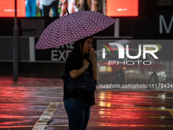 A woman is holding an umbrella in Hong Kong, on April 26, 2025. (