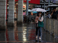 A woman is holding an umbrella in Hong Kong, on April 26, 2025. (