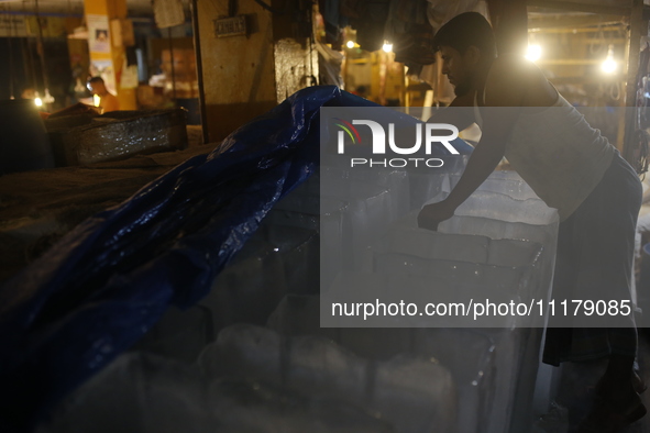 A man is storing ice bars for sale at a market during a heatwave in Dhaka, Bangladesh, on April 26, 2024. 