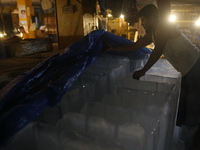 A man is storing ice bars for sale at a market during a heatwave in Dhaka, Bangladesh, on April 26, 2024. (