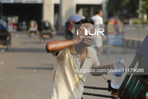 A rickshaw puller is splashing water on his face to find relief from a heatwave in Dhaka, Bangladesh, on April 26, 2024. 