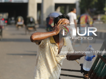 A rickshaw puller is splashing water on his face to find relief from a heatwave in Dhaka, Bangladesh, on April 26, 2024. (